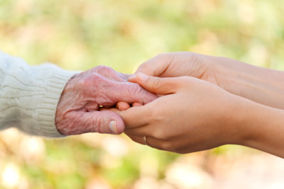 Senior and young holding hands